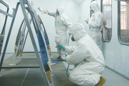 員工在密閉空間穿戴個人防護(hù)用品對汽車骨架進(jìn)行噴漆作業(yè)